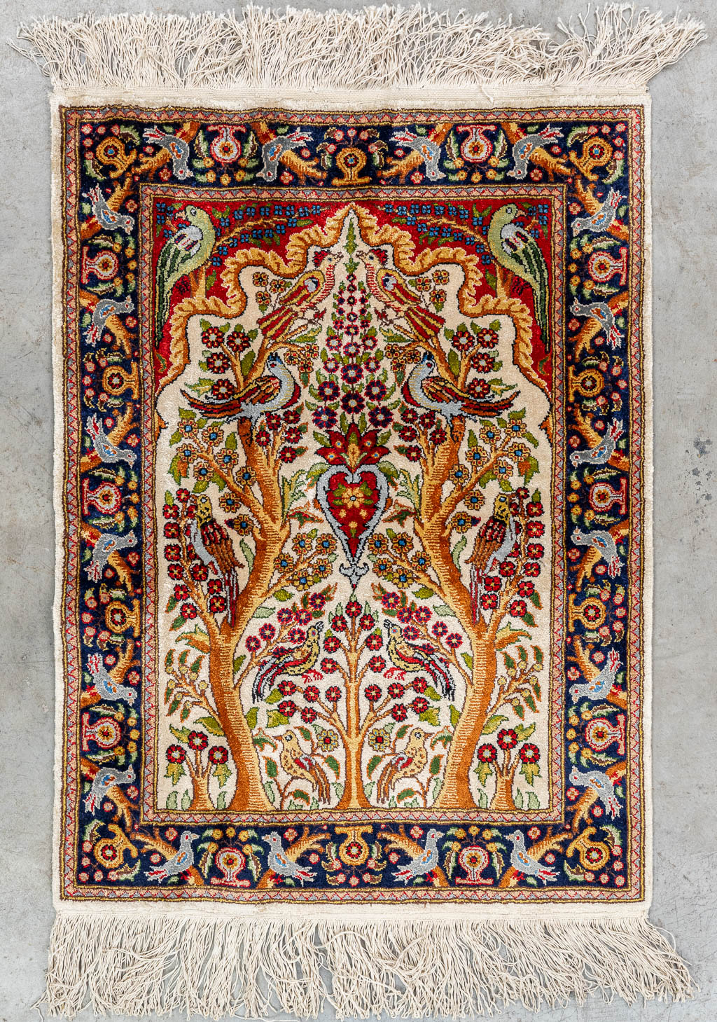 Een handgeknoopt tapijt met 'Levensboom'. (L: 80 x W: 58 cm)