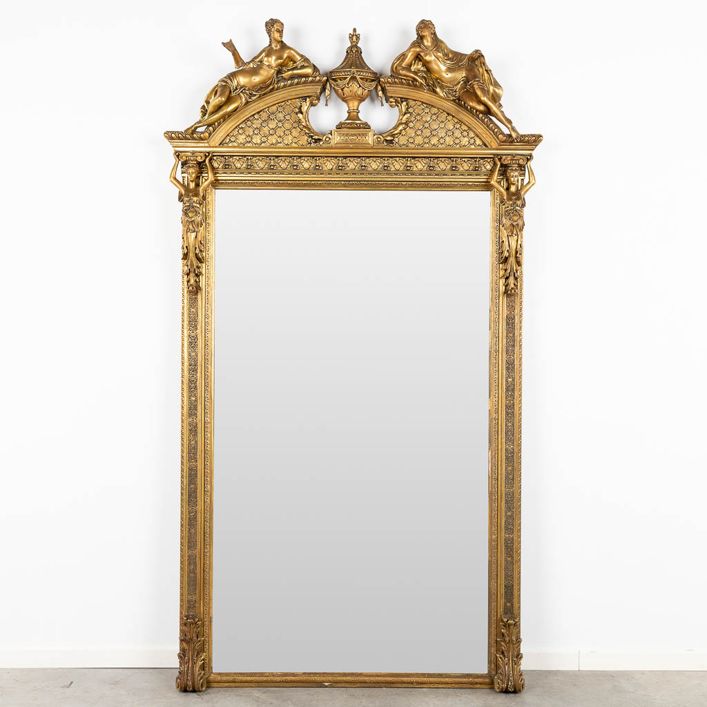 A large mirror, gilt and decorated with Kariatyds, circa 1900. (W:123 x H:220 cm)