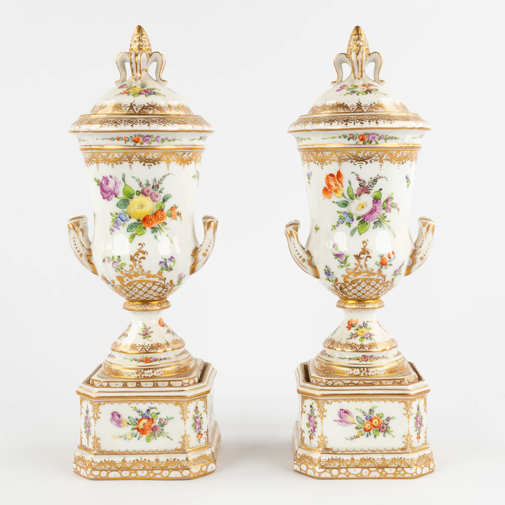 Dresden, a pair of polychrome urns with a lid. Hand-painted floral decor. (L:8,5 x W:9 x H:26 cm)