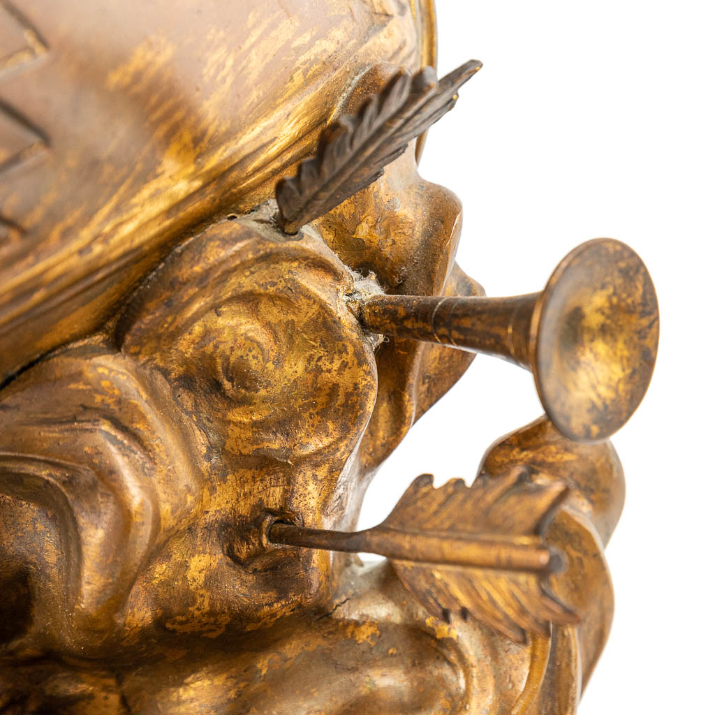 Een driedelige schouwgarnituur afgewerkt met putti en een satyr, gemaakt uit kunstbrons. (H:37cm)
