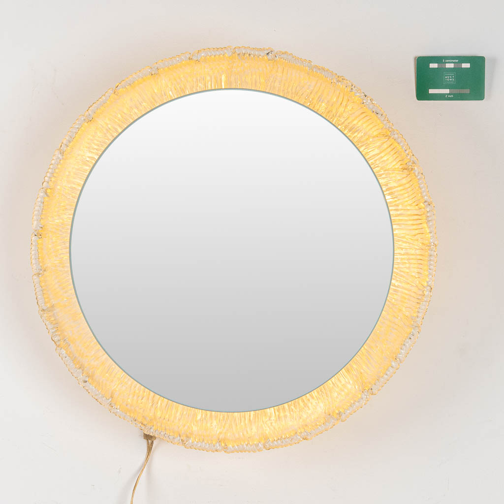 Een ronde spiegel met verlichting, acryl en glas, gemaakt door Deknudt. 