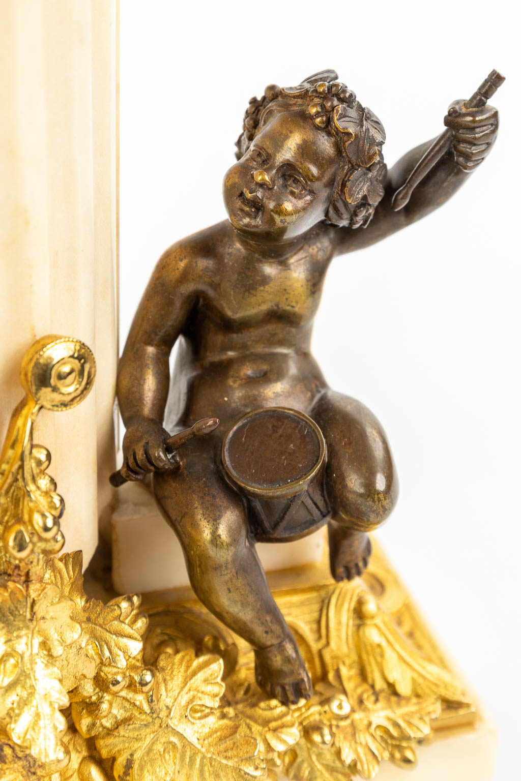 Een klok gemaakt uit marmer en versierd met verguld en gepatineerd brons in Lodewijk XVI stijl. (H:42cm)