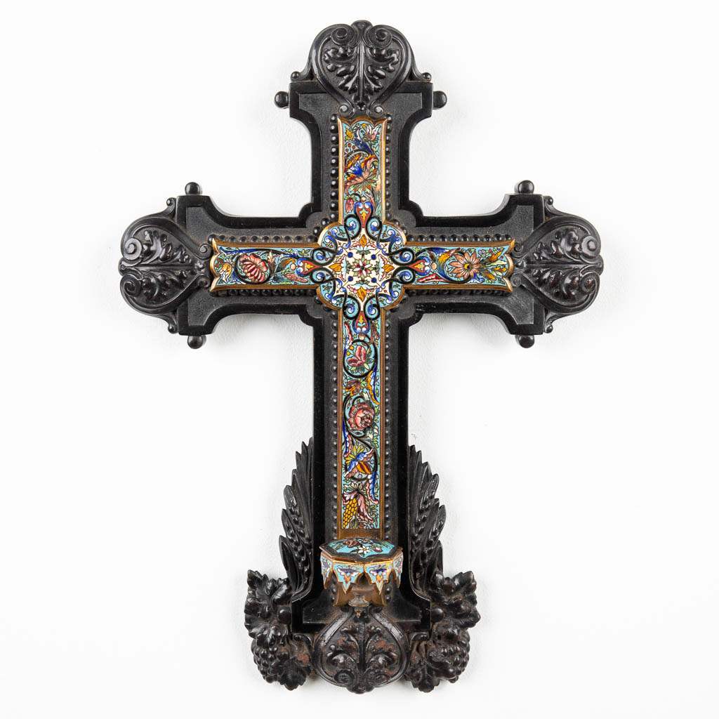 Een kruisbeeld afgewerkt met champleve inlegwerk en wijwatervat in gesculpteerd ebbenhouten kruis. (H:43cm)