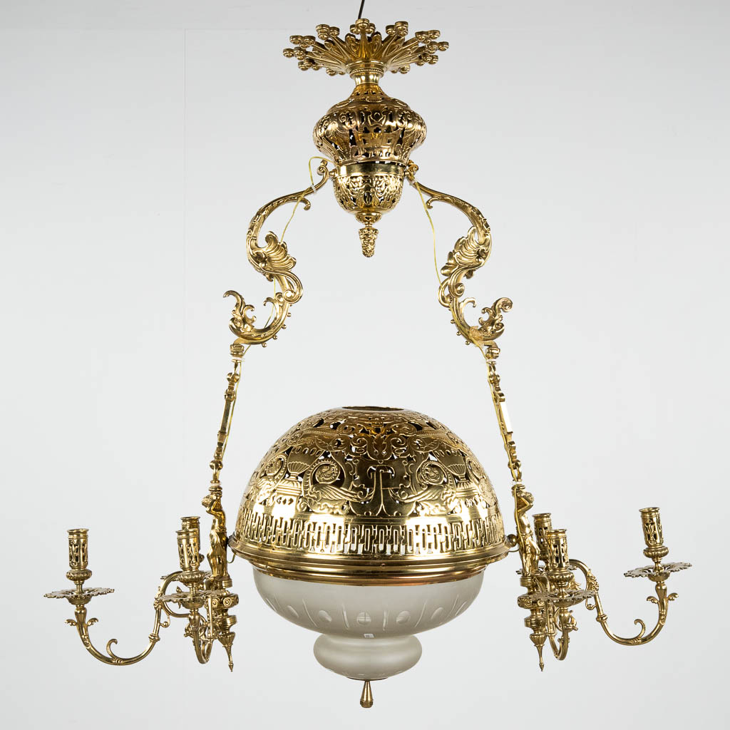 Een grote 'Lampe Belge' decor van putti, brons en glas. 20ste eeuw. (D:40 x W:94 x H:97 cm)