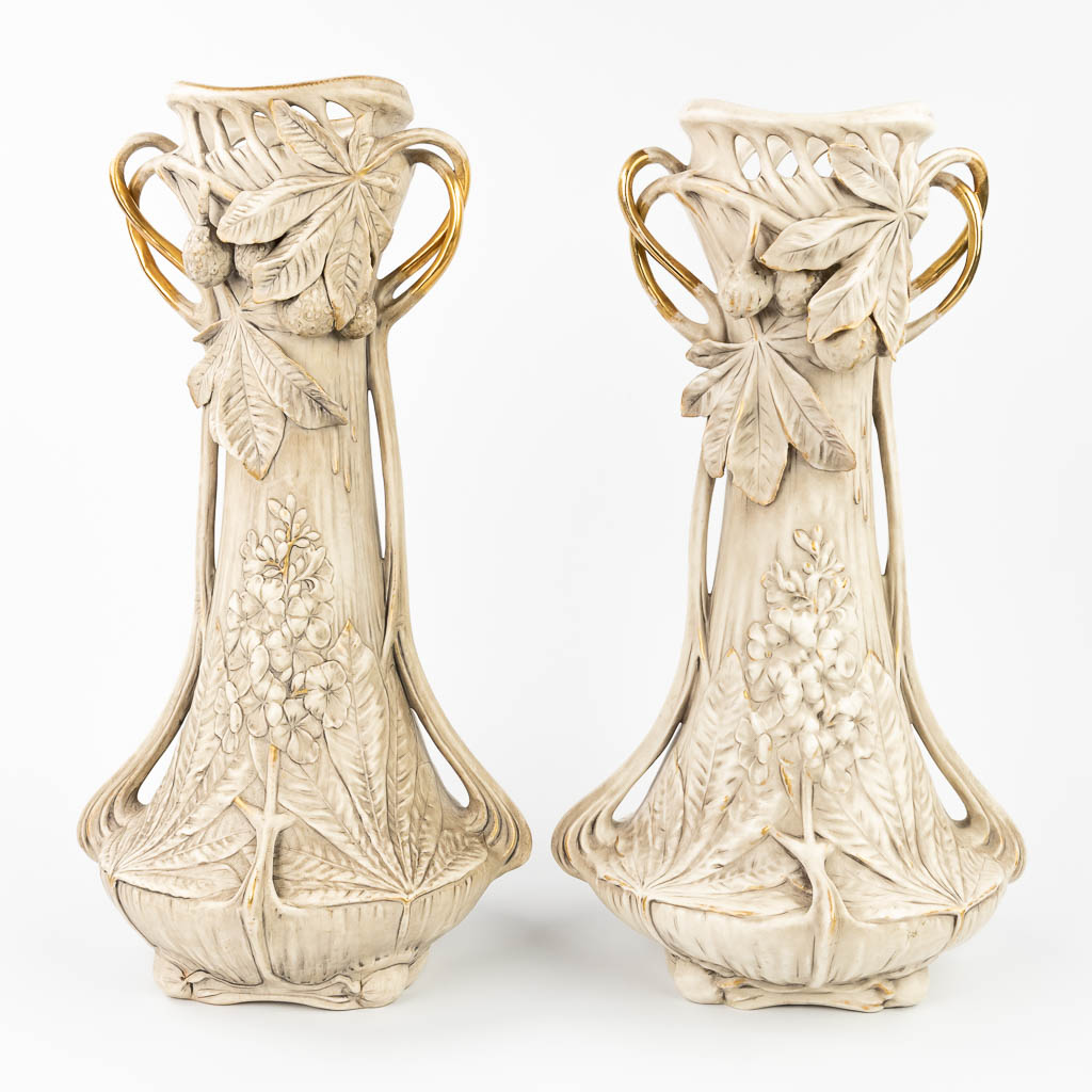 Royal Dux, een paar vazen gemaakt uit faience in art nouveau stijl met florale decors.  (L:24 x W:28 x H:52 cm)