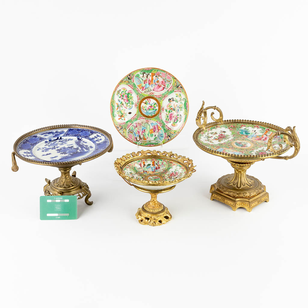 Three tazzas made of porcelain on a bronze base added a Kanton plate. 19th/20th C. (D:23 x W:29 x H:22 cm)