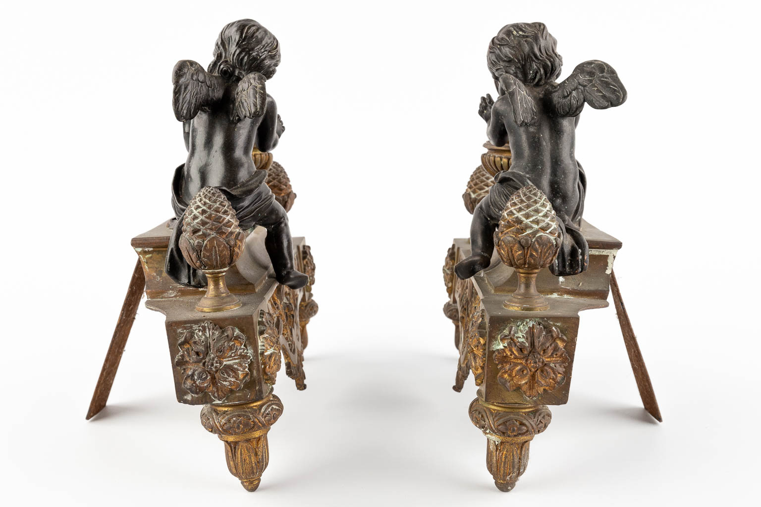 Een paar haardvuurbokken, gepatineerd en verguld brons, Lodewijk XVI stijl. 19de eeuw. (W:30 x H:27 cm)
