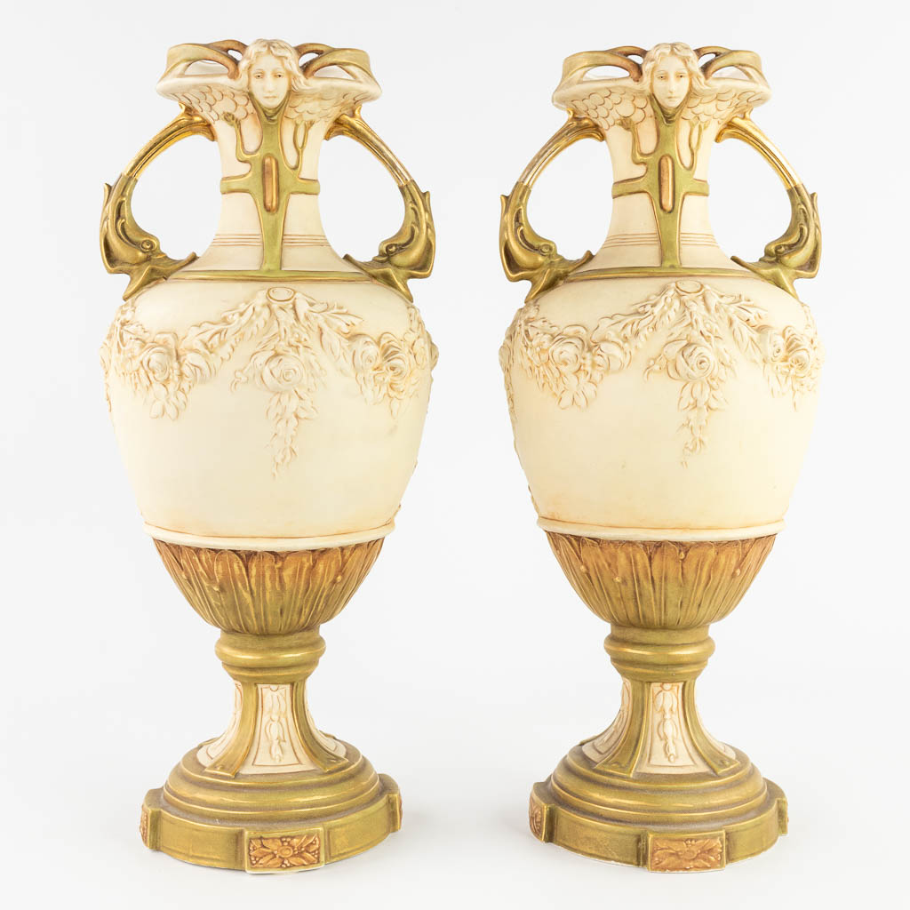 Royal Dux, a three-piece mantle garniture consisting of a statue and two vases. (L:20 x W:28 x H:43 cm)