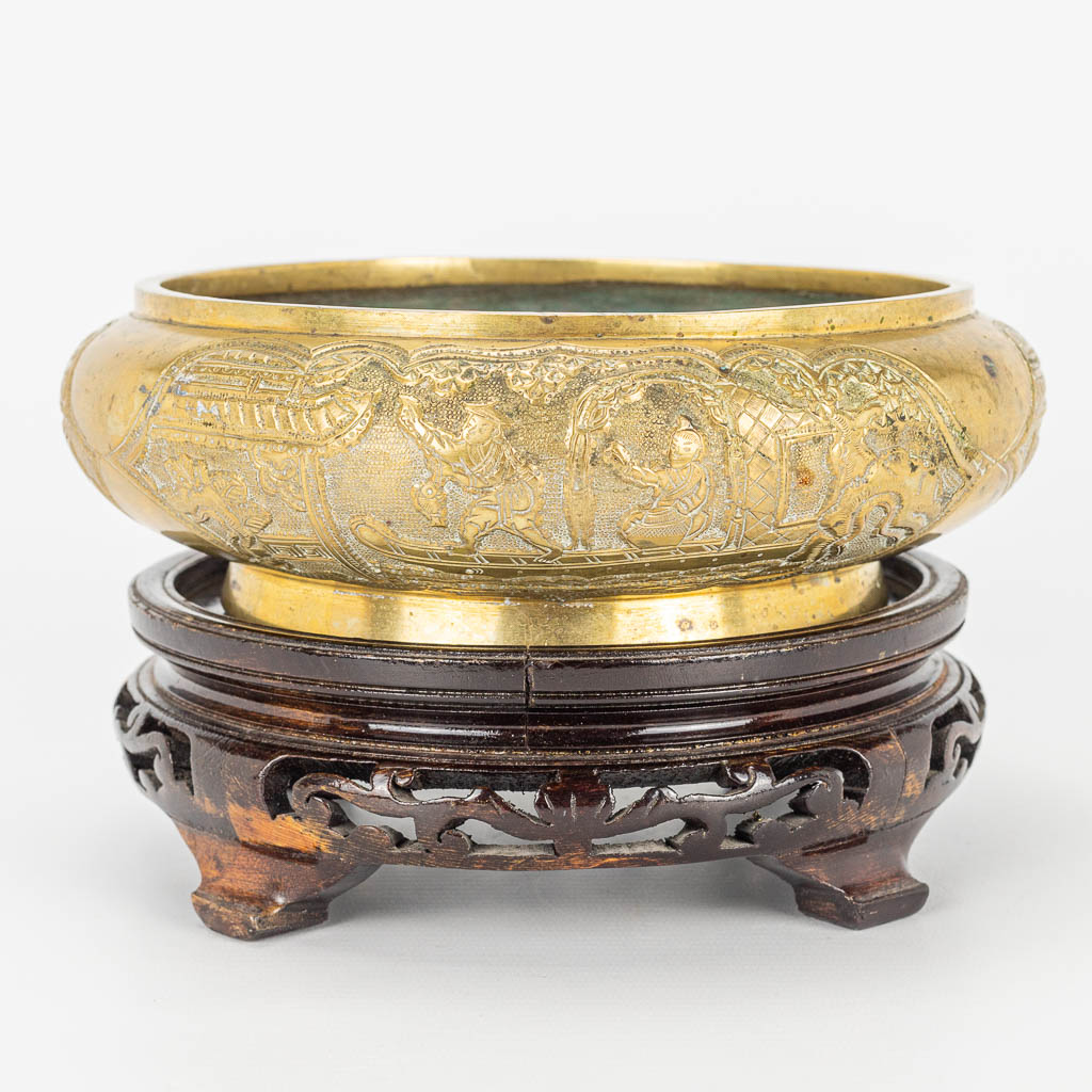 A bronze brûle parfum bowl, on a wood base. Marked Xuande. 