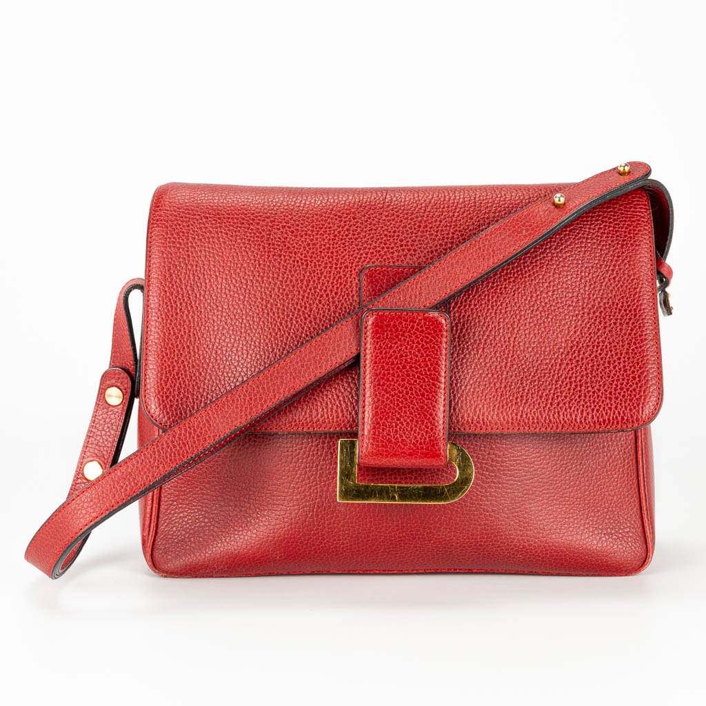 A purse made of red leather and marked Delvaux.