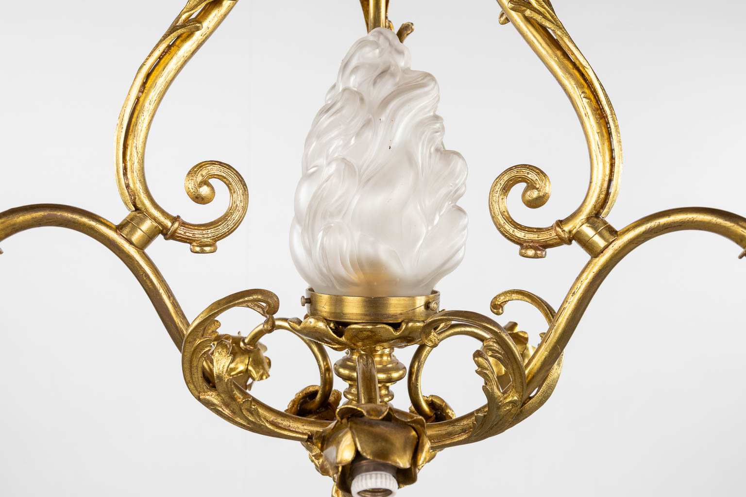 Een luchter met glazen flambeau, verguld brons afgewerkt met saterfiguren. (H:88 x D:54 cm)