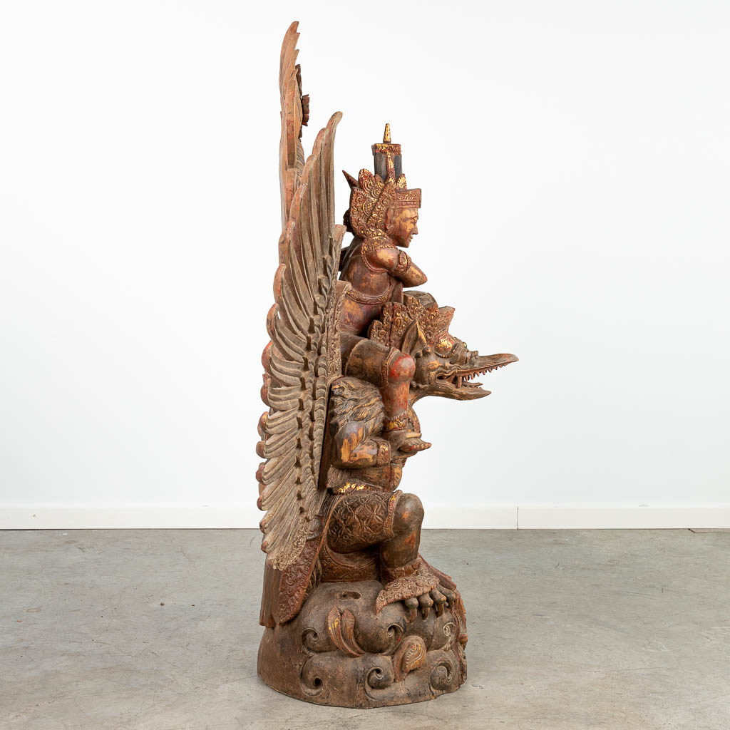 Een grote houtsculptuur van een ruiter op een mythologische draak. Waarschijnlijk gemaakt in Indonesië. (H:126cm)