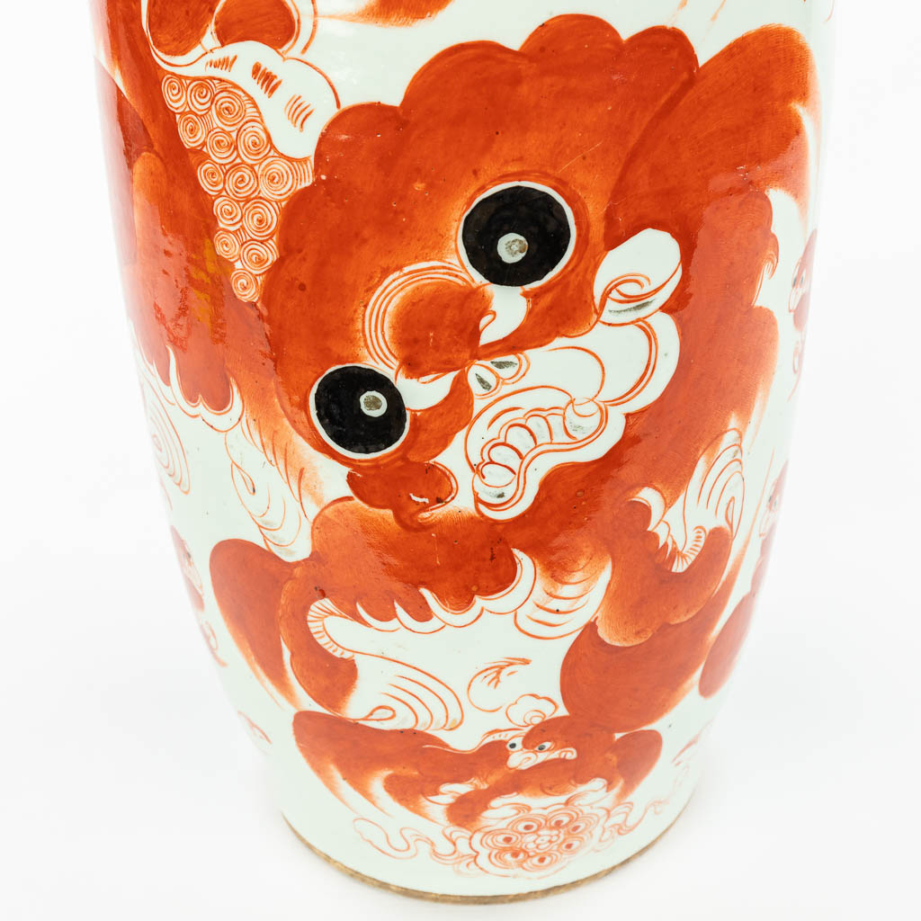 A Chinese vase made of porcelain and decorated with a red foo dog. (H:59cm)