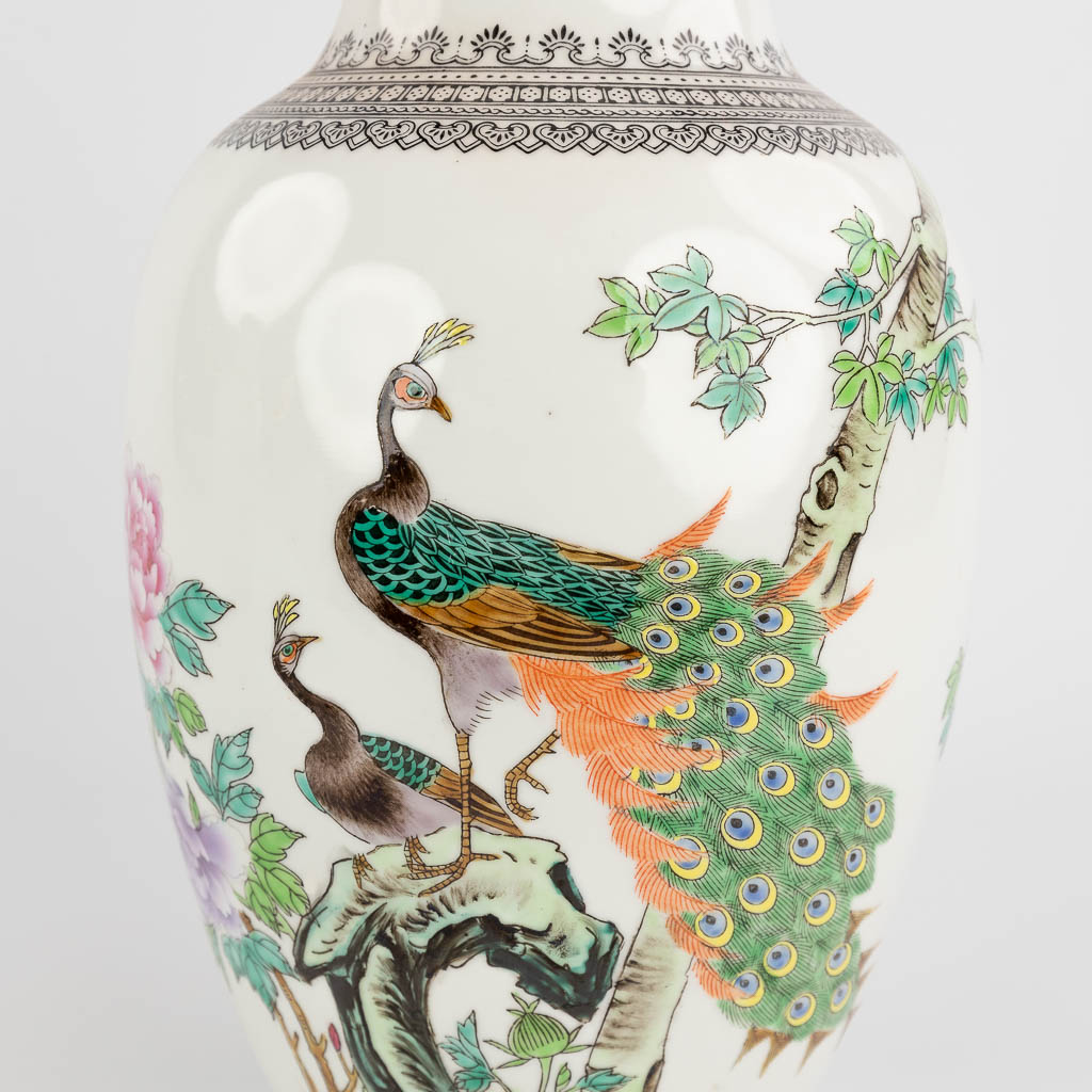 Een paar Chinese vazen, porselein afgewerkt met handgeschilderde pauwen. 20ste eeuw. (H: 36 x D: 17 cm)