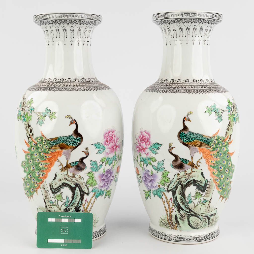 Een paar Chinese vazen, porselein afgewerkt met handgeschilderde pauwen. 20ste eeuw. (H: 36 x D: 17 cm)
