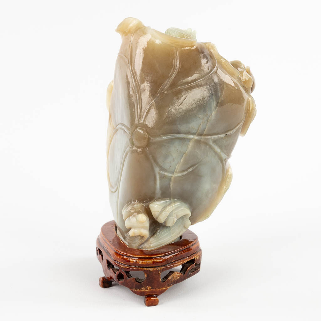 A Chinese, bicoloured Jade figurine of Guan-yin in a lotus flower. 20th C. (D:10 x W:10 x H:16 cm)
