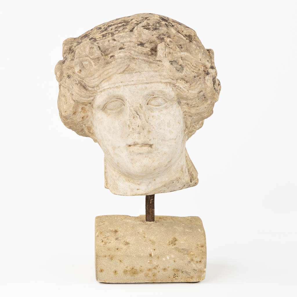An antique sculptured marble head of a lady, mounted on a base. Probably of Roman origin. (L:25 x W:24 x H:26 cm)