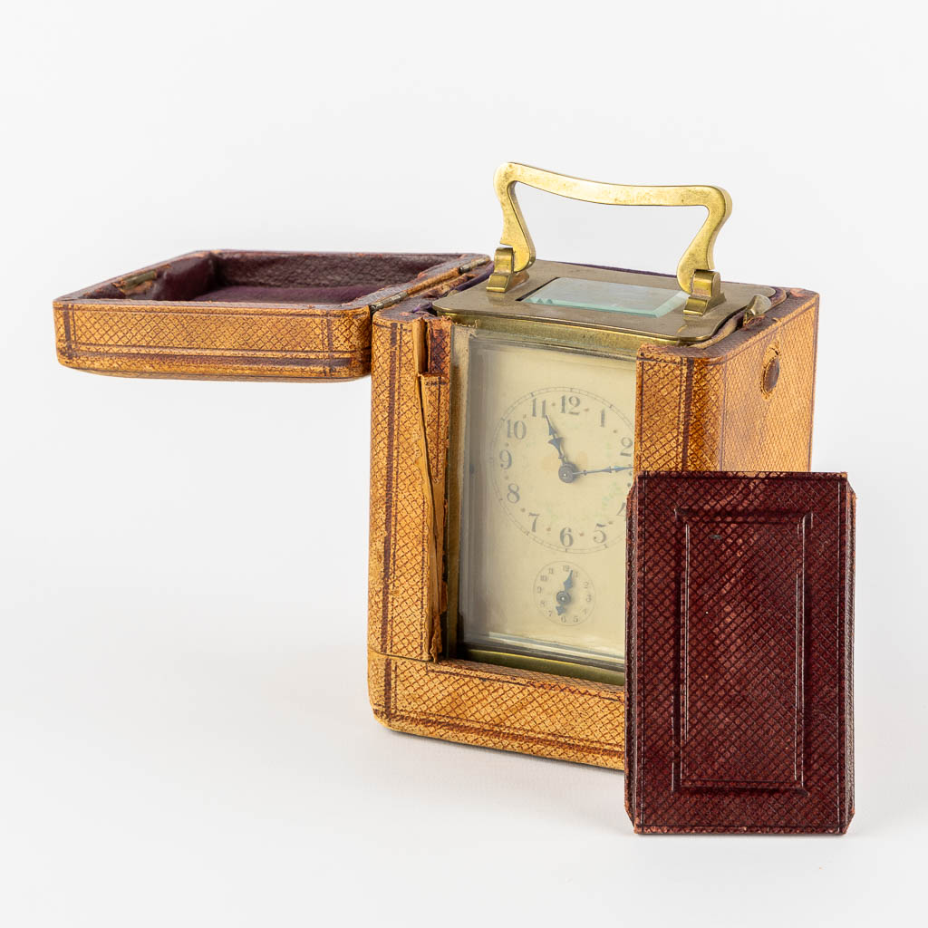 An officer's clock, brass and glass in the original travel case. (L:6,5 x W:8 x H:15 cm)