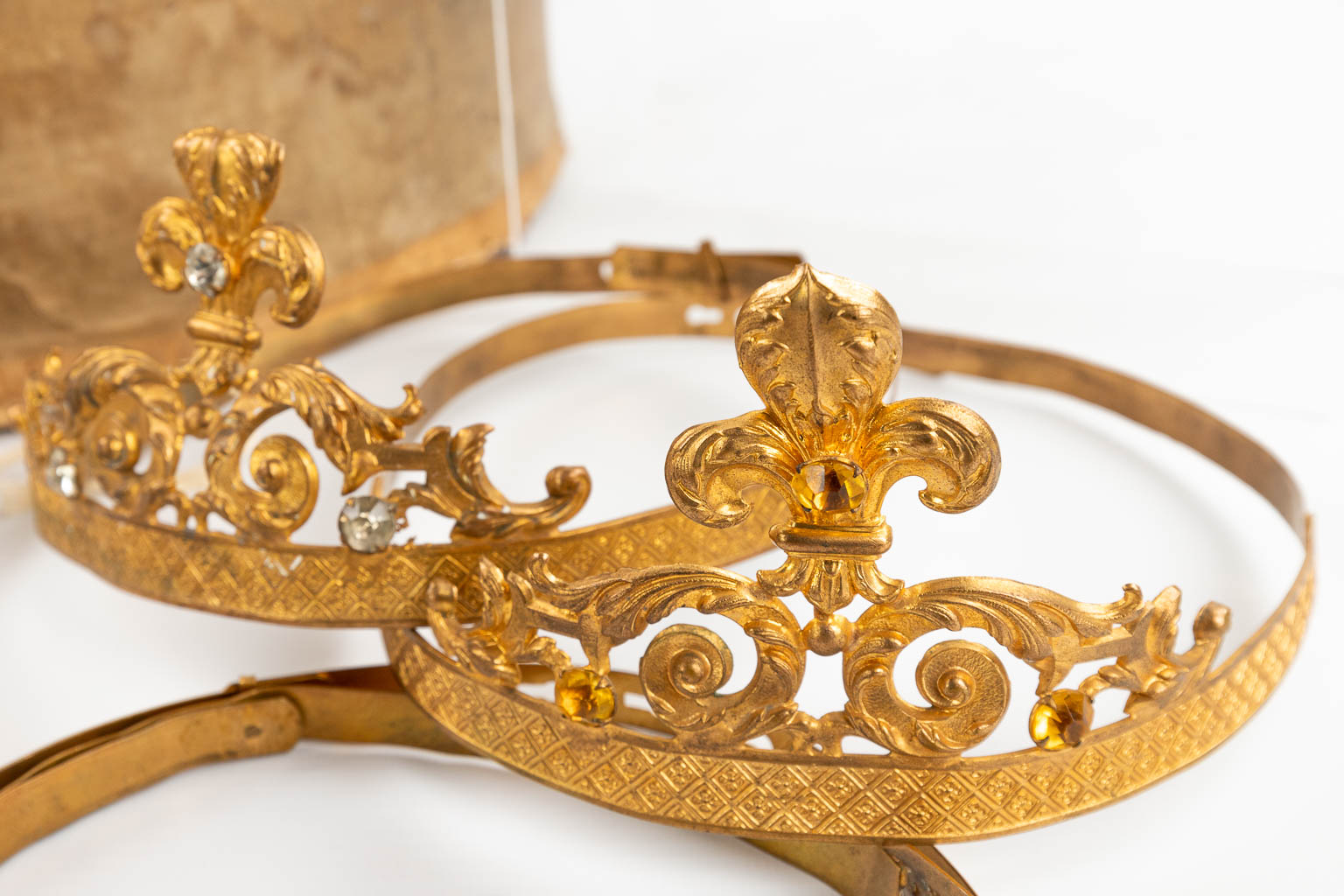 A large collection of big and small crowns for holy statues, and a staff. 