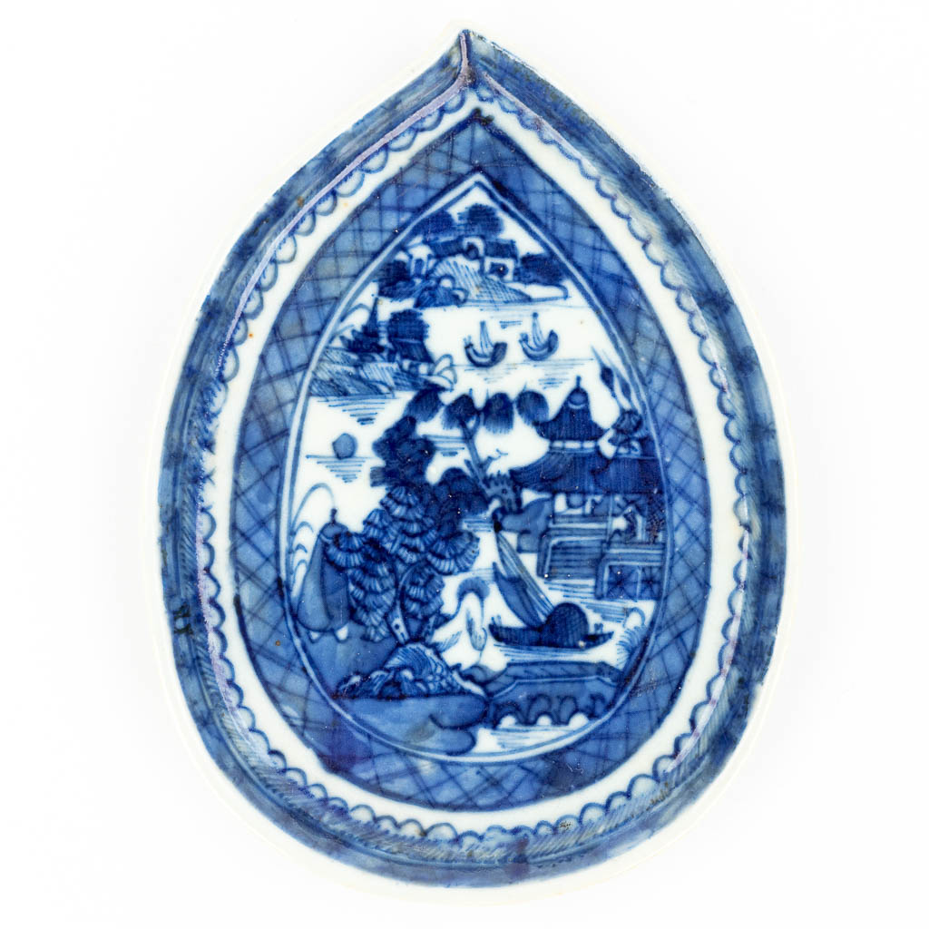 A Chinese dish made of porcelain with a blue-white landscape decor. 