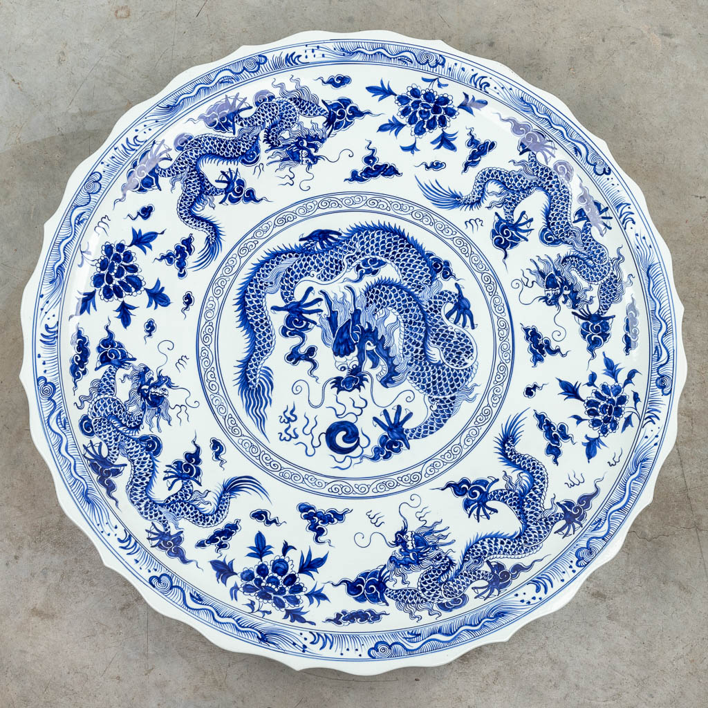 Lot 058 A huge Chinese plate, decorated with a blue-white decor with dragons. 20th century. 