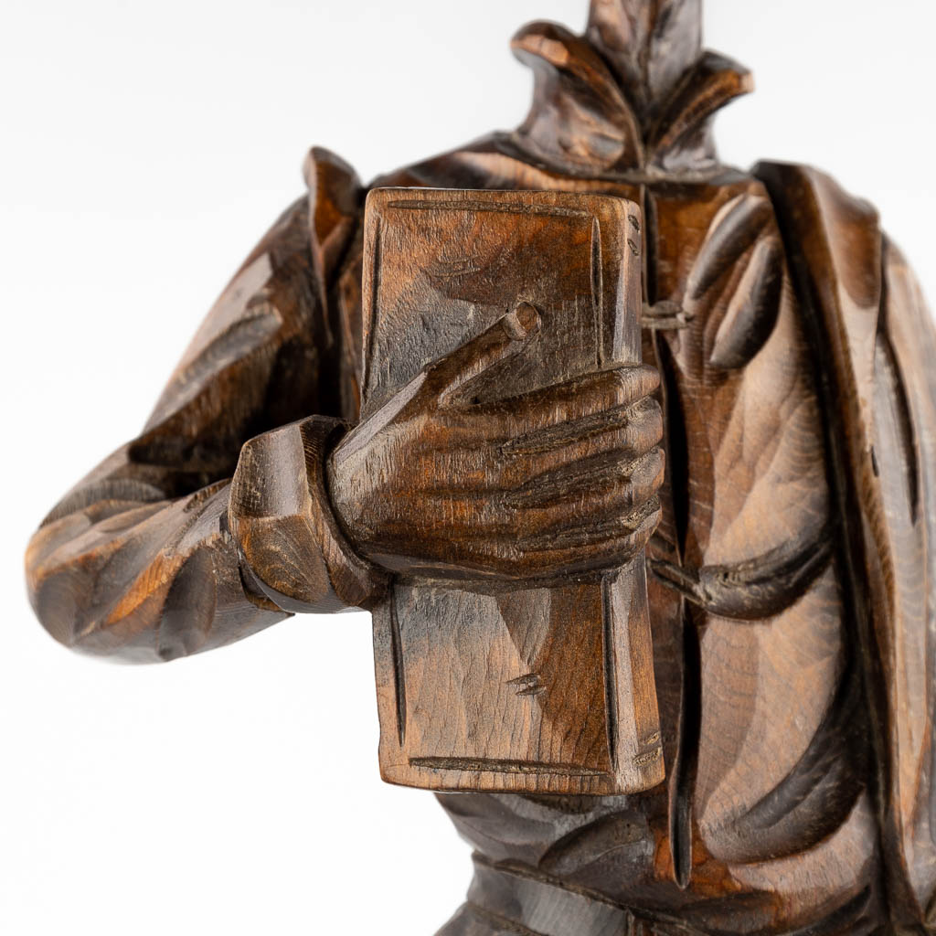 A wood sculpture of a nobleman with a book, circa 1900. (D:15 x W:22 x H:71 cm)