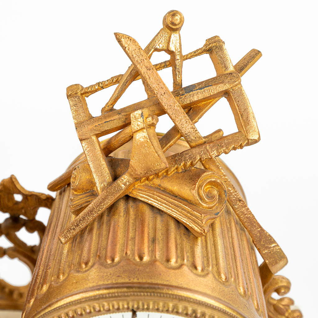 Een driedelige schouwgarnituur gemaakt uit verguld kunstbrons en albast, staande onder drie globes (H:31cm)