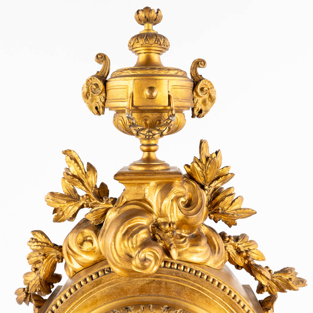 An antique mantle clock, gilt bronze in a Louis XVI style, decorated with ram