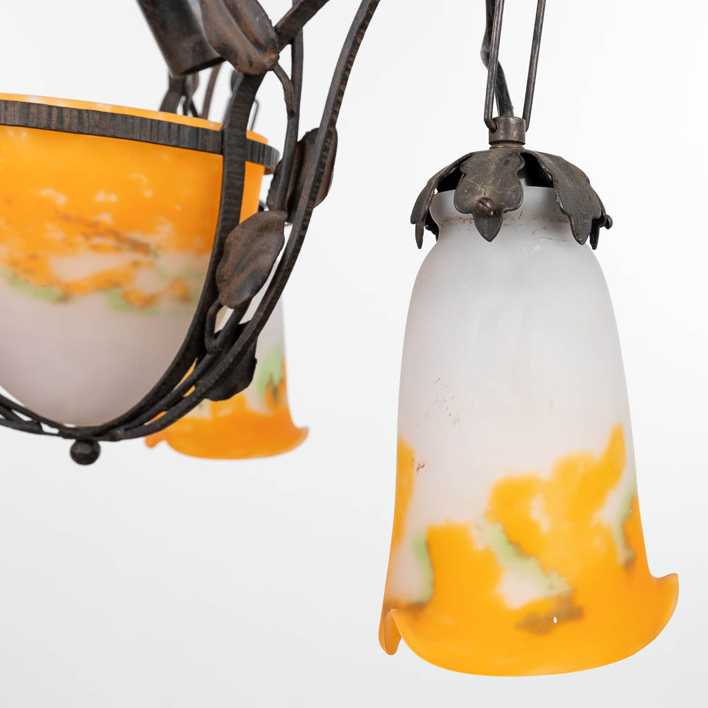 Een luchter gemaakt in art deco stijl uit smeedijzer en afgewerkt met pate-de-verre lampkappen gemerkt Muller. (H:100cm)