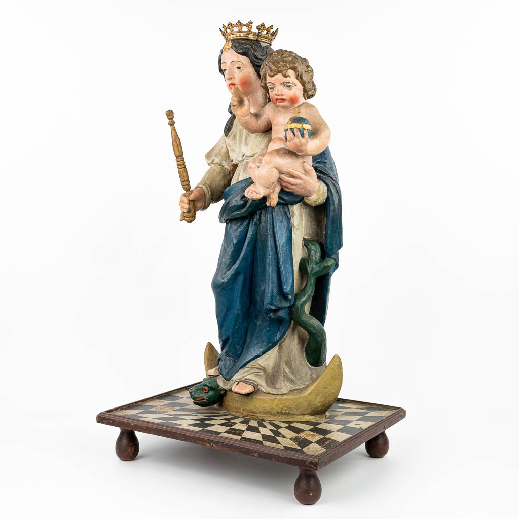 Een gepatineerd houten beeld van Madonna met kind, bovenop het serpent en een maansikkel (H: 90 cm)