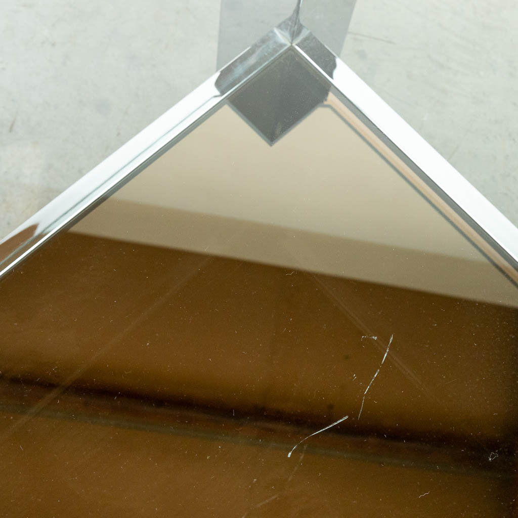 Een salontafel gemaakt uit gechromeerd metaal met fumé en doorzichtig glas. Belgo Chrom