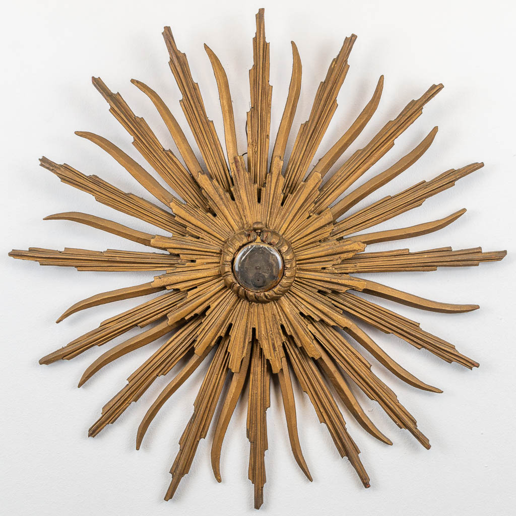 A pocket watch and a sunburst holder made of sculptured wood, 19th century. 