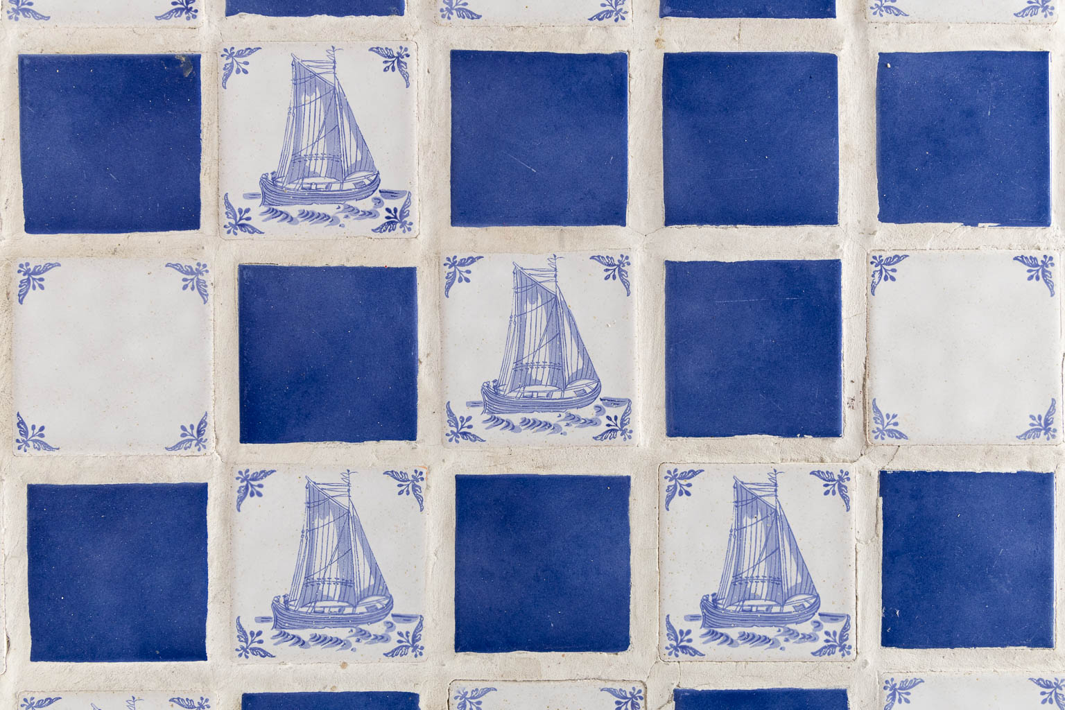 Een Spaanse tafel afgewerkt met blauwe en witte faience tegels. (L:85 x W:184 x H:76 cm)