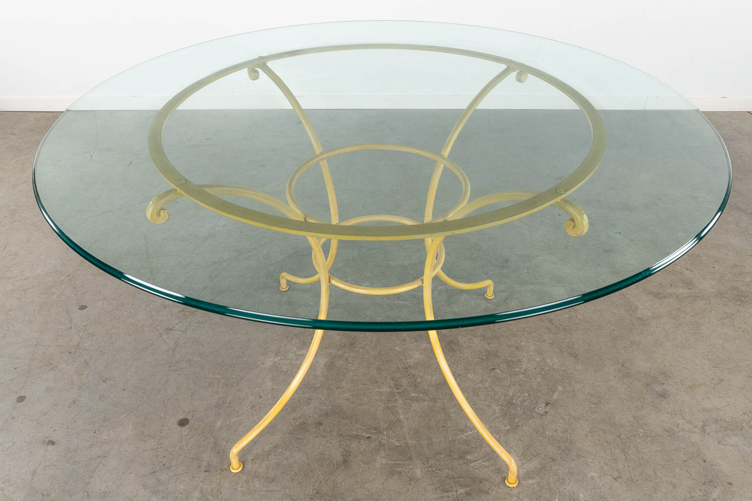 Een ronde tafel met 6 bijhorende stoelen, gepatineerd metaal. 20ste eeuw. (H:77 x D:130 cm)