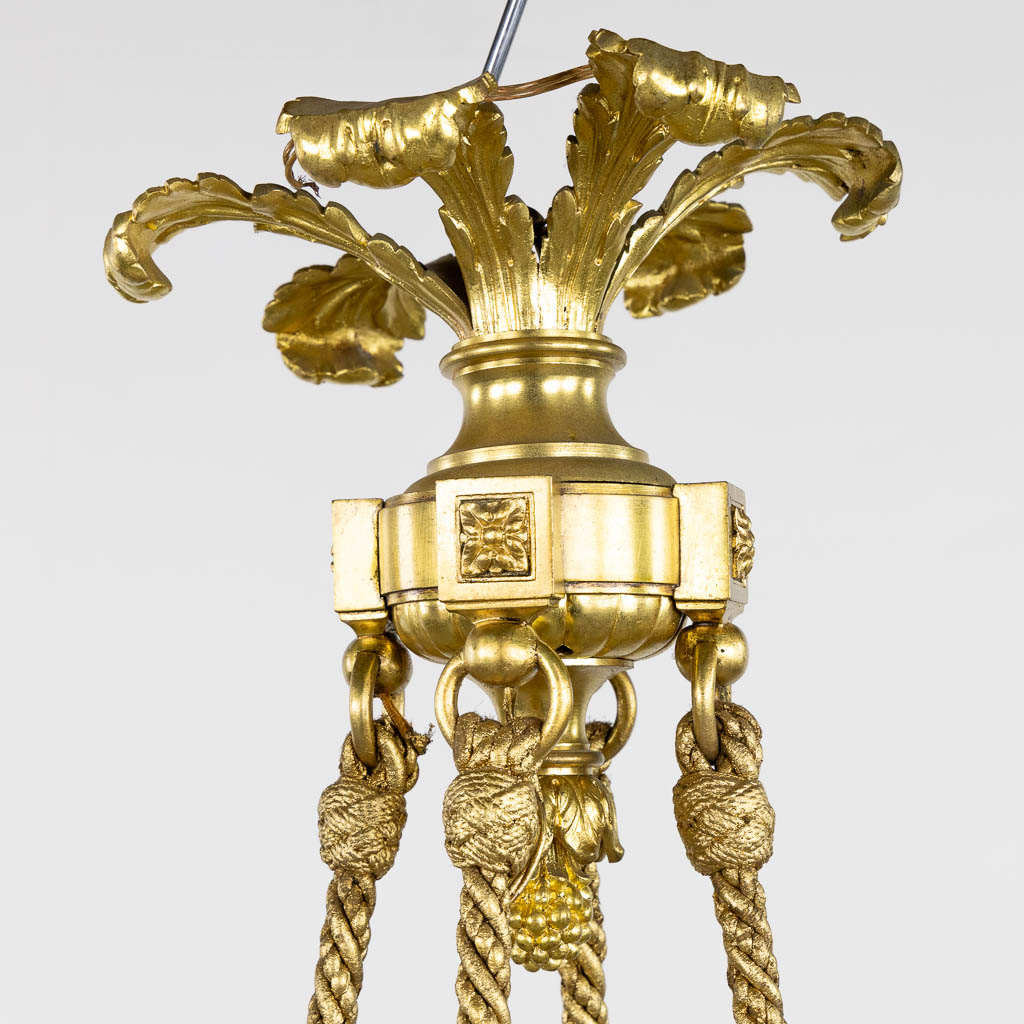 A chandelier, bronze in a Louis XVI style. Gilt bronze. (H:100 x D:72 cm)