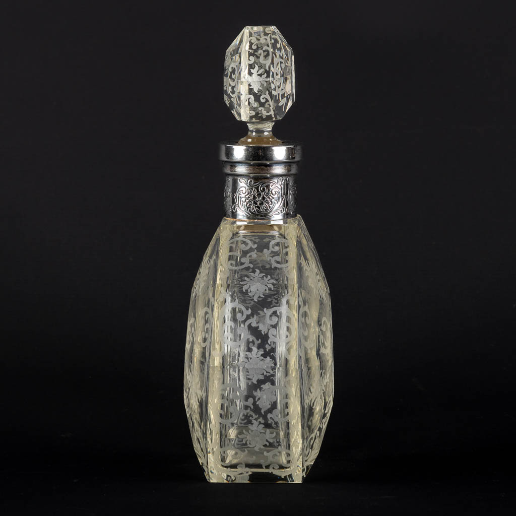 A perfume bottle, etched and mounted with a silver collar, glass. 19th C. (L:8 x W:17 x H:26,5 cm)