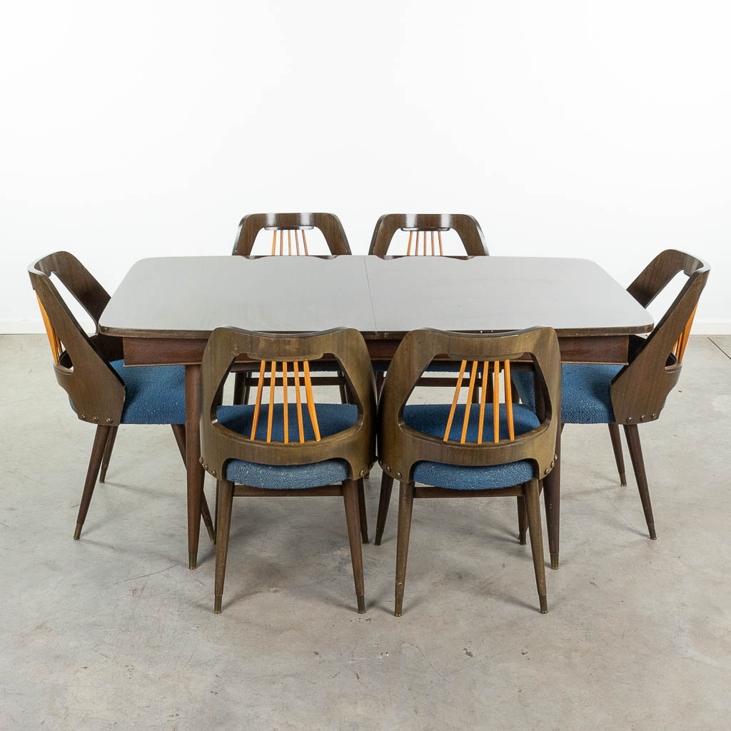  Een mid-century tafel met 6 stoelen, met uitschuifbaar tafelblad. Circa 1950. (95 x 160 x 77cm)
