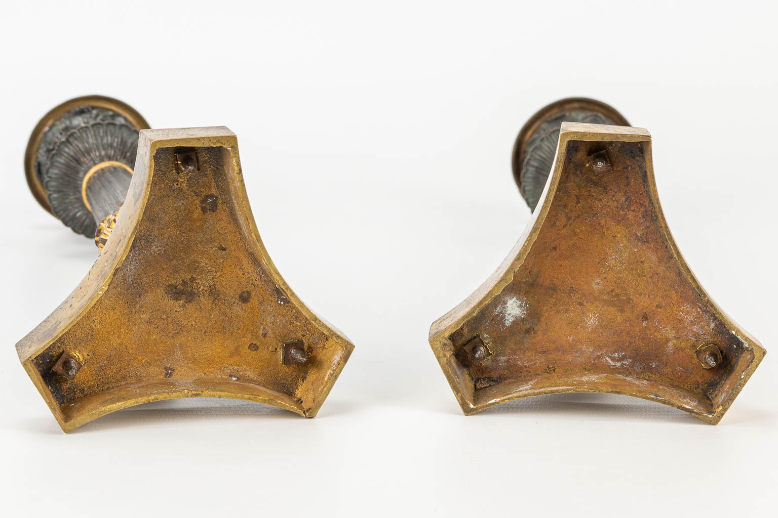 Een paar kandelaars gemaakt uit verguld en gepatineerd brons in empire stijl. 