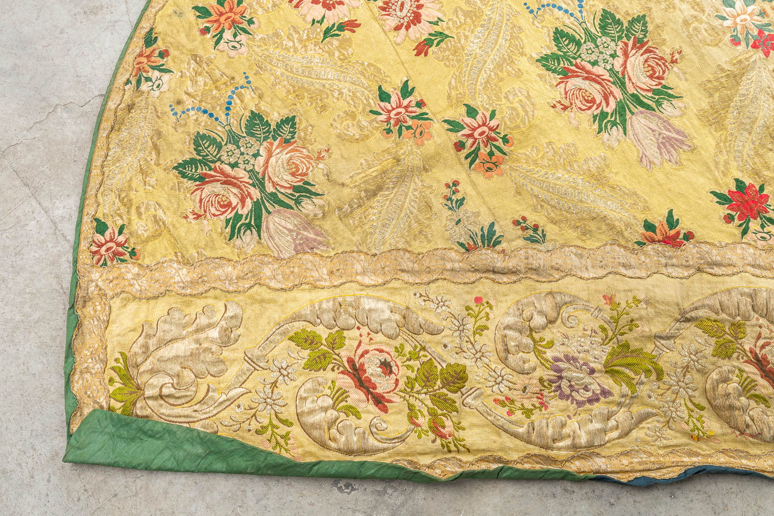 Een koorkap - koormantel versierd met bloemen en een witte duif, afgewerkt met geborduurd gouddraad. (H:128cm)