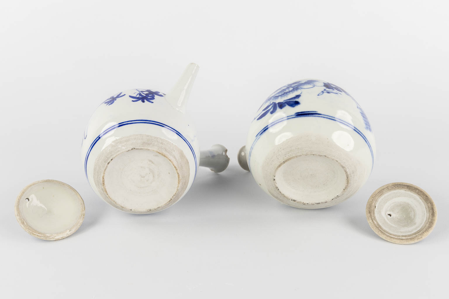 Three Chinese and Japanese teapots, blue-white decor. (W:20 x H:14 cm)