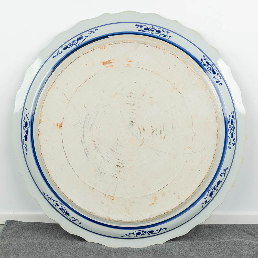 A huge Chinese plate, decorated with a blue-white decor with dragons. 20th century. 