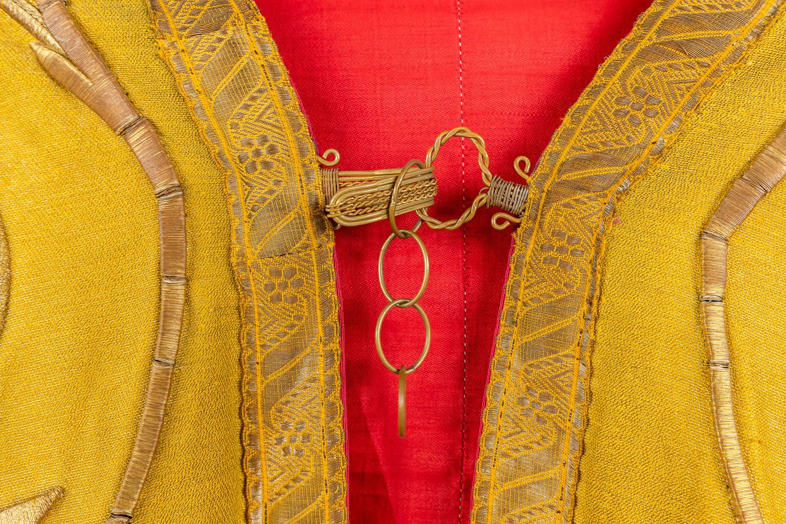 Een Koorkap, twee schoudervelums, een Romeinse kazuifel, afgewerkt met dik goudbrokaat borduurwerk.