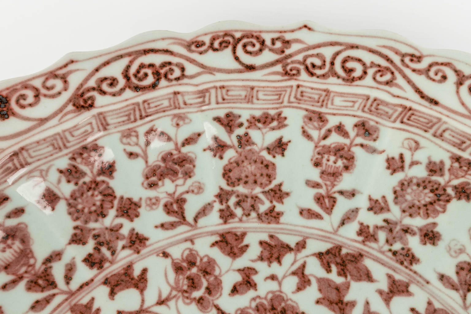 Een grote Chinese schaal, rode glazuur met pioenrozen. 19de/20ste eeuw. (D:46 cm)