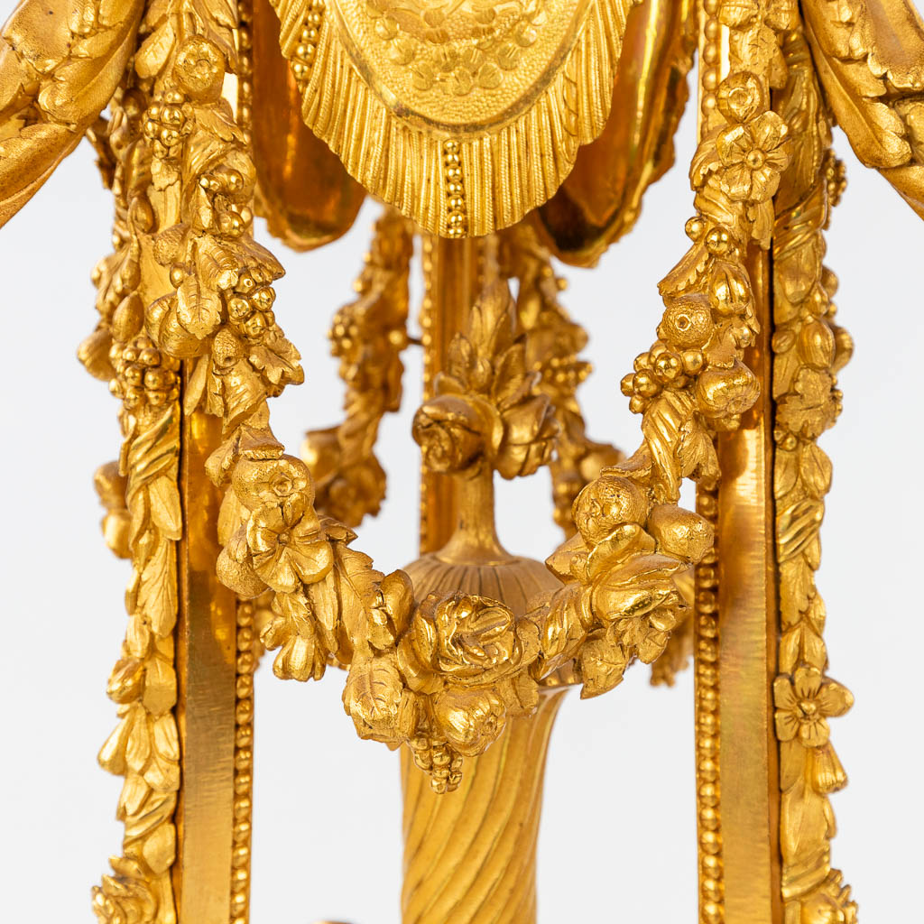 Een imposante driedelige schouwgarnituur, klok met kandelaars, verguld brons in Lodewijk XVI stijl. Maison Marquis, Paris. (H: 9