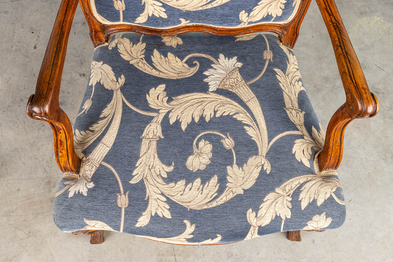 An armchair made in a Louis XV style and upholstered with fabric. Around 1800. (H:96cm)
