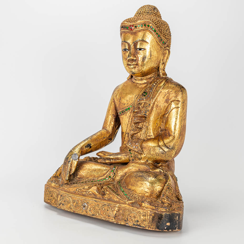 Een Oosterse houten en gesculpteerde Boeddha.