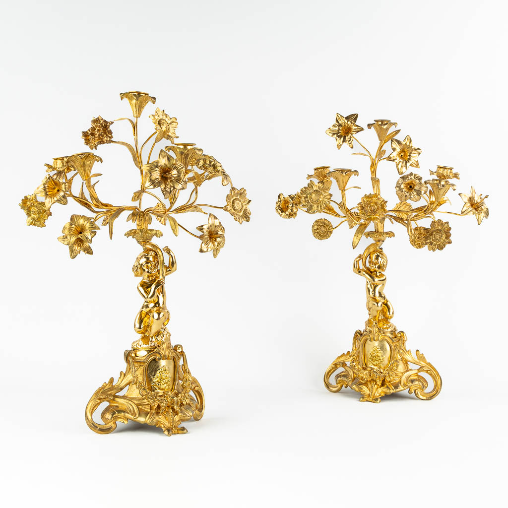 A pair of candelabra, gilt bronze decorated with putti and flowers. 19th C. (L:22 x W:36 x H:53 cm)