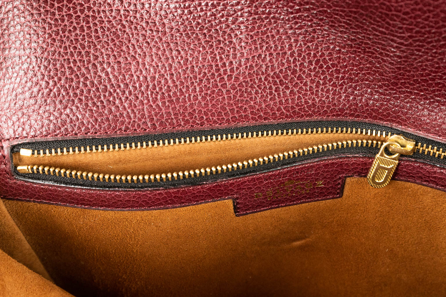 A purse made of red leather and marked Delvaux. (H:18cm)