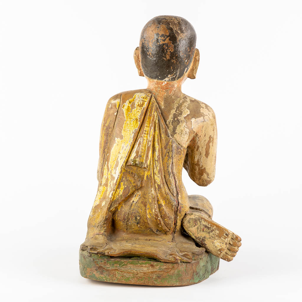 An antique wood-sculptured figurine of a monk. 18th/19th C. (L:36 x W:30 x H:47 cm)