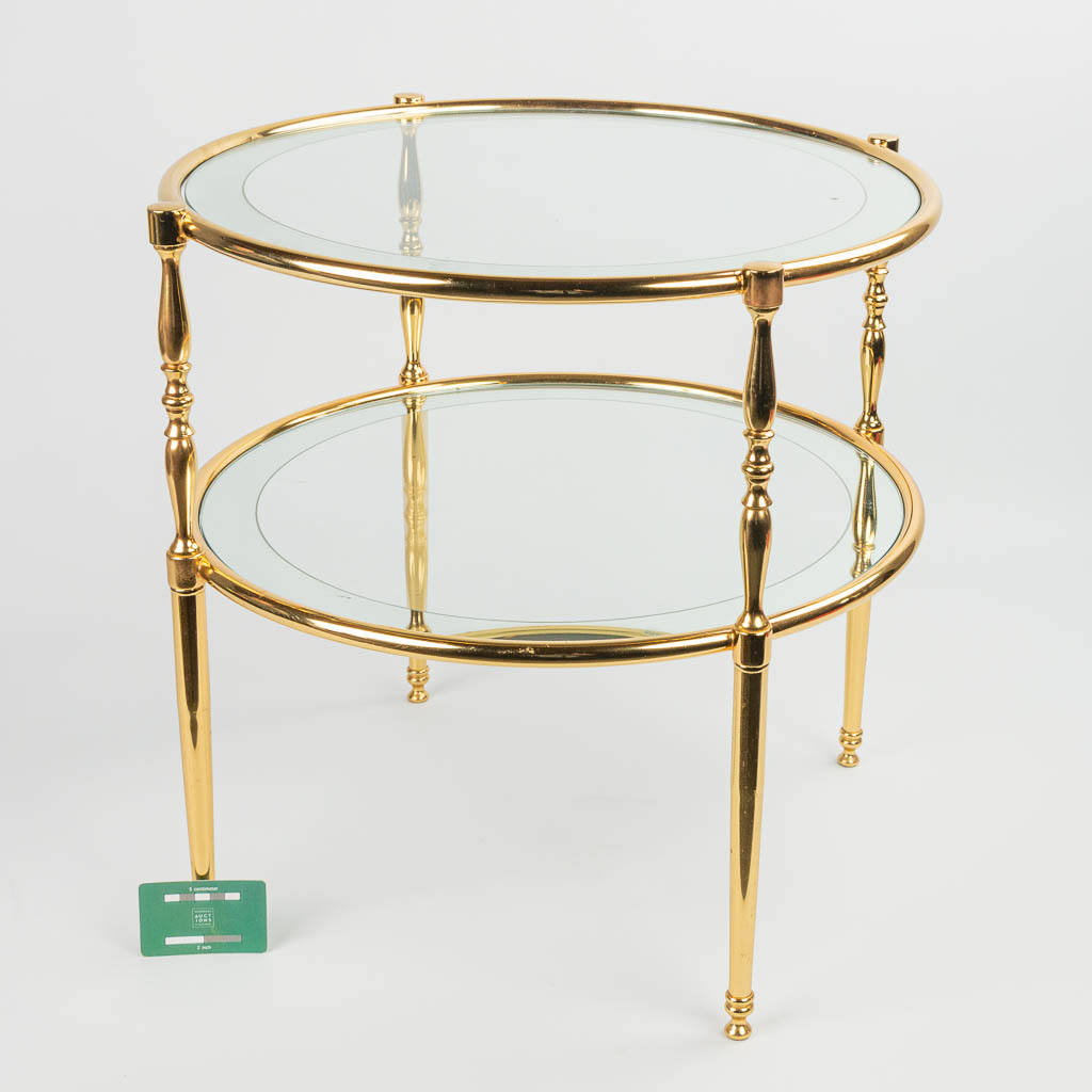 een mid-century salontafel gemaakt uit koper en glas, waarvan de rand gespiegeld is. 